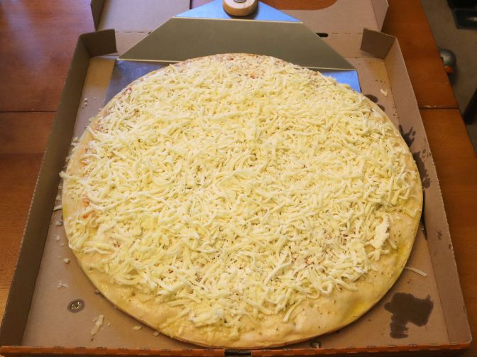 Picture of uncooked pizza with extra cheese.